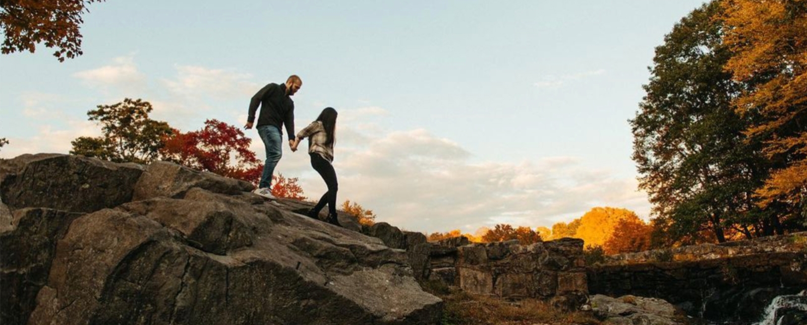 Couple hiking along rocks at Southford Falls (Instagram@zacpaul_photo)