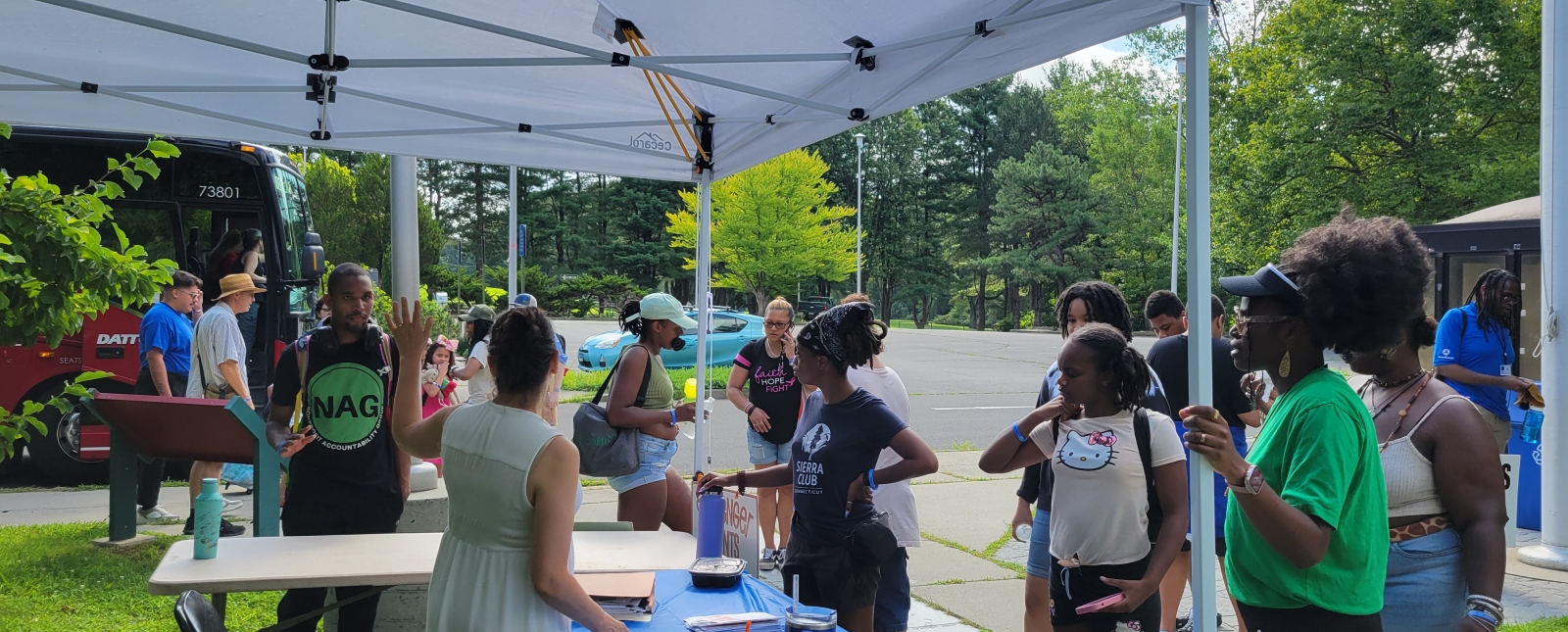 Group of people standing at a registration table/tent