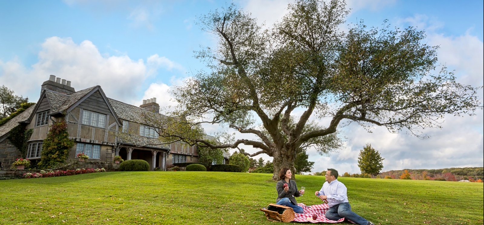 Couple picnicking in front of Topsmead State Park, Litchfield