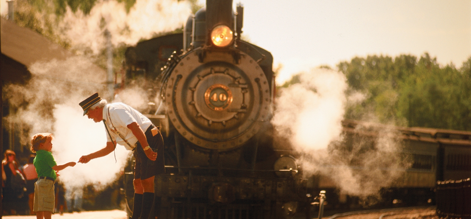 A train engineer and child on platform near approaching train (CTVisit)