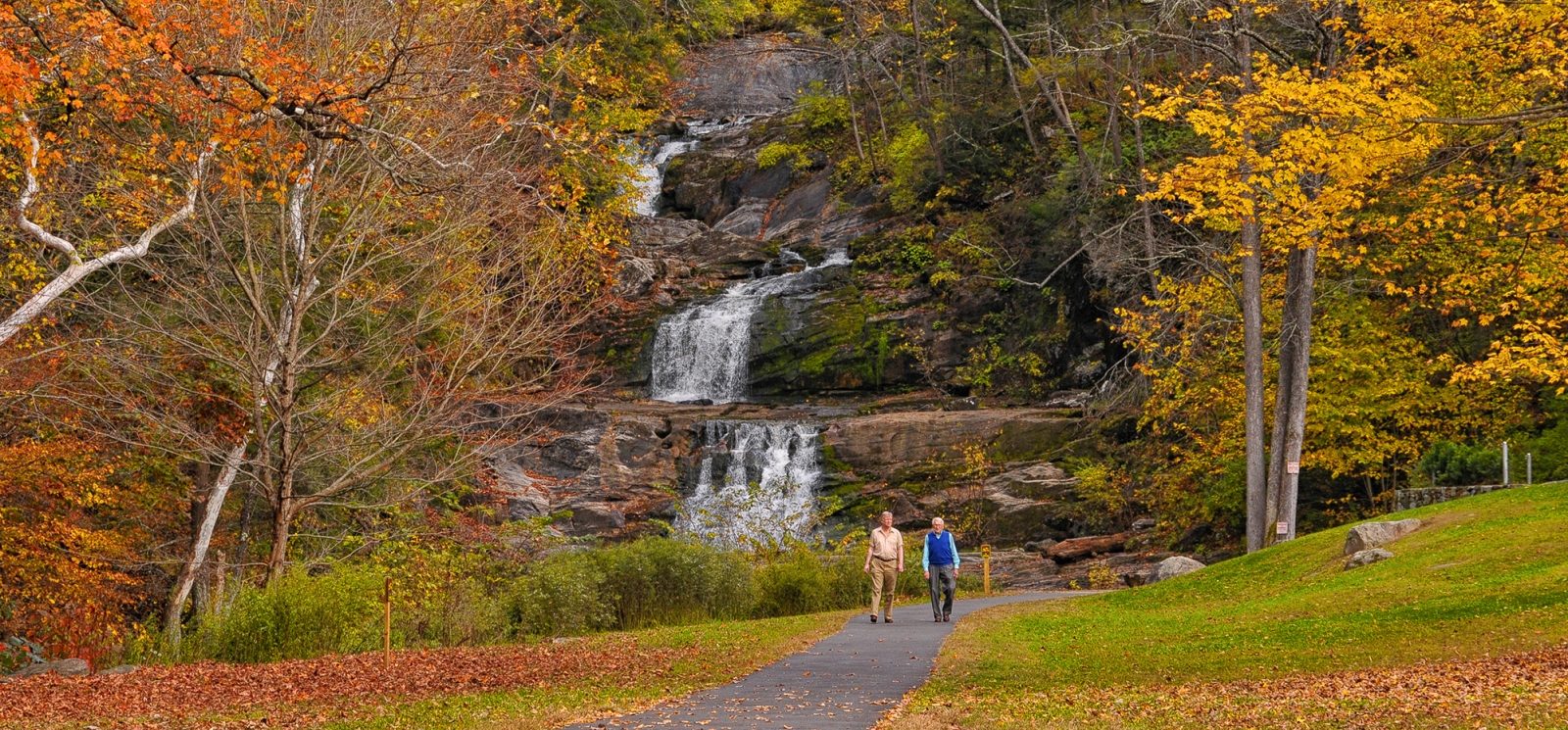 Couple walking along path at Kent Falls during peak foliage