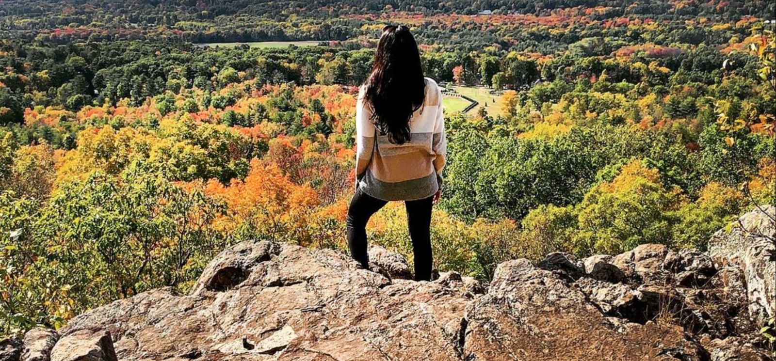 A woman stands on a rock overlooking the fall scenery (Instagram@fromramonawlove)