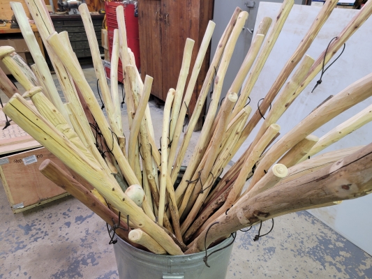 container of wooden hiking sticks
