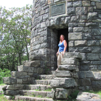A woman standing on steps of a stone tower (Flickr@blazer=696)