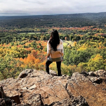 A woman stands on a rock overlooking the fall scenery (Instagram@fromramonawlove)