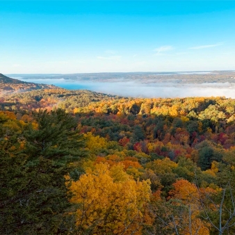 A mountain top view of fall tree tops (Instagram@isthierc)