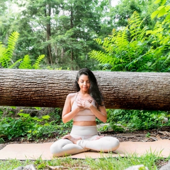 Woman practicing yoga by fallen tree (Instagram@mikaila_nyc)