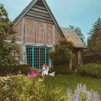 Woman reading a book in front of Topsmead (Instagram@somethingwanderfull)