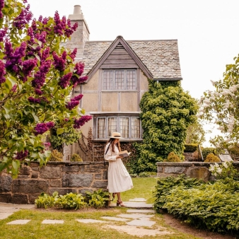 Woman reading book in front of Topsmead (Instagram@livelovelytravel)